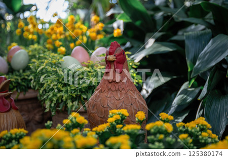 Handmade decorative chicken figure and pastel eggs in garden setting. Spring and Easter symbol 125380174