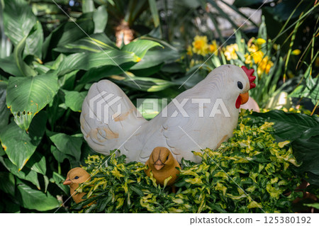 Handmade decorative chicken figure in garden setting. Spring and Easter symbol 125380192