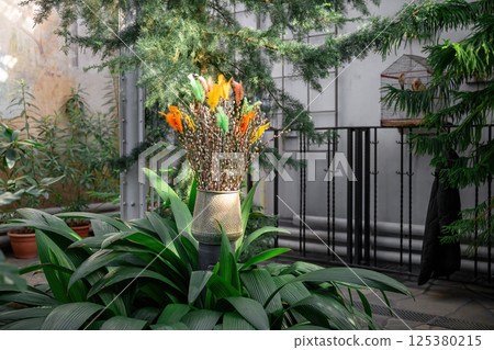 Pussy willow branches with colorful feathers in spring sunlight close-up 125380215