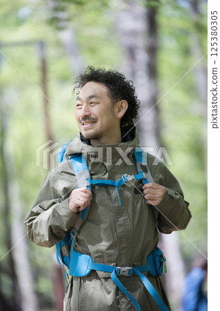 Close-up of a middle-aged man hiking or climbing looking up at the view 125380305