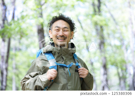 中年男子徒步或登山，看著相機 125380306