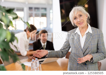 Friendly businesswoman invites you to visit the office of company Friendly businesswoman invites you to visit the office of company 125380505