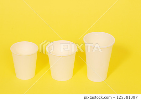 Image of disposable cups on yellow background 125381397