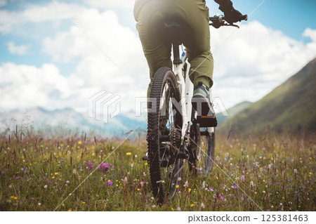 Riding mountain bike in the flowering beautiful mountain top Riding mountain bike in the flowering beautiful mountain top 125381463