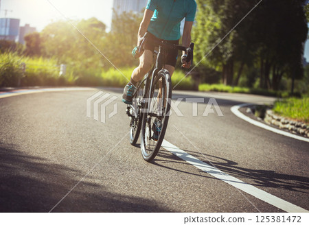 Woman cycling on summer park trail 125381472