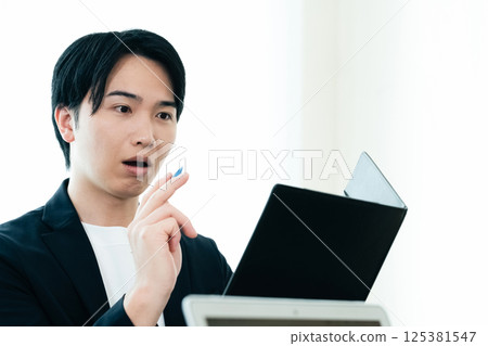 A casual-style businessman examining documents A casual-style businessman examining documents 125381547