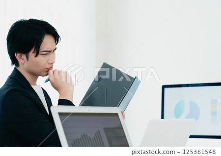 一位休閒風格的商人正在審查文件 125381548