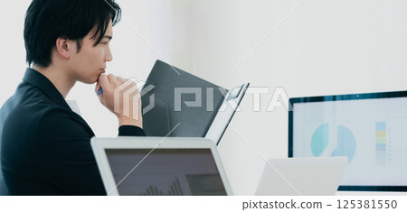 一位休閒風格的商人正在審查文件 125381550