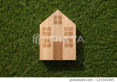 Wooden house on the grass, smart construction concept. Wooden house on the grass, smart construction concept. 125381805