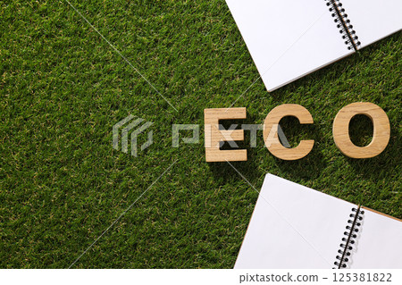 A paper notebook with a pencil on the grass. 125381822