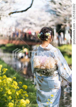 A middle-aged woman in a kimono sightseeing with a small boat crossing the Shingashi River, turned into a flower raft 125381882