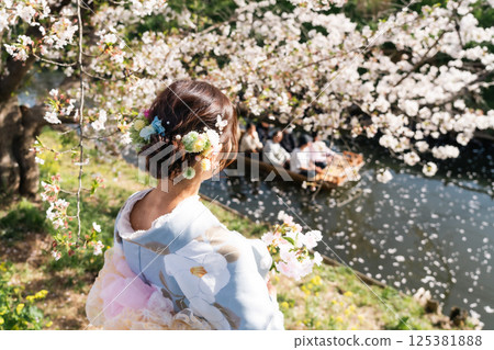 A middle-aged woman in a kimono sightseeing with a small boat crossing the Shingashi River, turned into a flower raft 125381888