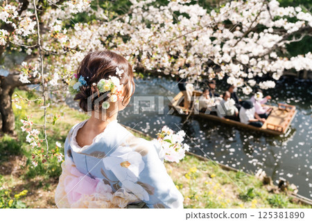 A middle-aged woman in a kimono sightseeing with a small boat crossing the Shingashi River, turned into a flower raft 125381890