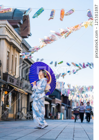 A middle-aged woman in a kimono strolling along Taisho Roman Street A middle-aged woman in a kimono strolling along Taisho Roman Street 125381897