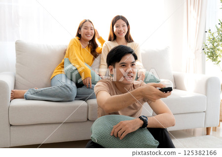 Group young asian friends watching TV together in a cozy living room at home with happy. Group young asian friends watching TV together in a cozy living room at home with happy. 125382166