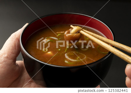 用筷子夾起豆腐蘑菇紅味噌湯裡的蘑菇 125382441