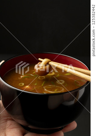 用筷子夾起豆腐蘑菇紅味噌湯裡的蘑菇 125382442