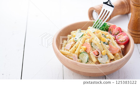 Macaroni salad served in a wooden bowl 125383122