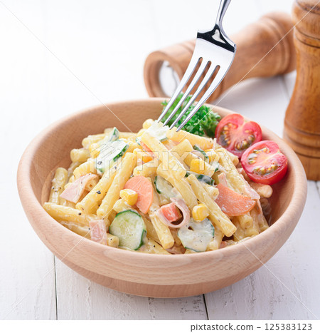 Macaroni salad served in a wooden bowl 125383123