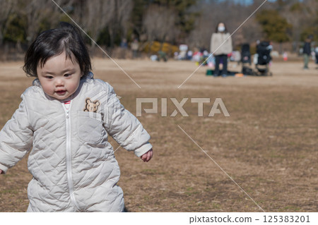 [一歲兒童在相模原市立麻溝公園的草地上玩耍] 125383201