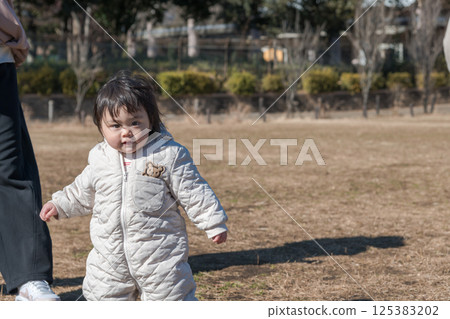 [一名一歲兒童和他的母親在相模原市麻溝公園的草地上玩耍] 125383202