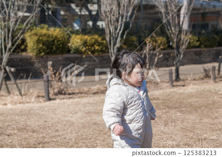 [一歲兒童在相模原市立麻溝公園的草地上玩耍] 125383213