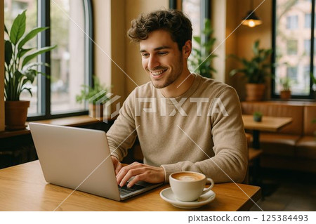 A young freelancer working in a cozy cafe with natural daylight. 125384493