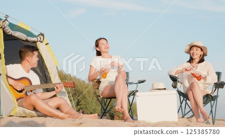 Happy friends with drinks in camp and laughing together in holidays on sand beach near camping tent vacation time at sunset, Young Asian group woman and man in summer travel outdoor Happy friends with drinks in camp and laughing together in holidays on sand beach near camping tent vacation time at sunset, Young Asian group woman and man in summer travel outdoor 125385780