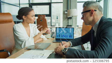 Business partners analyzing infographic data report 125386795