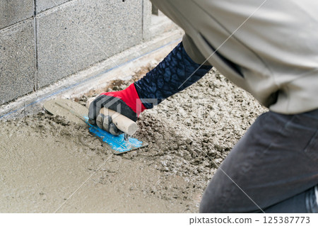 A plasterer is a craftsman who finishes concrete. 125387773