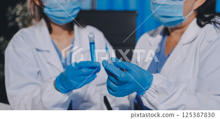 Researcher using a professional microscope 125387830