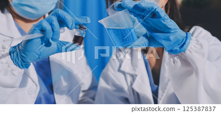 Researcher using a professional microscope 125387837