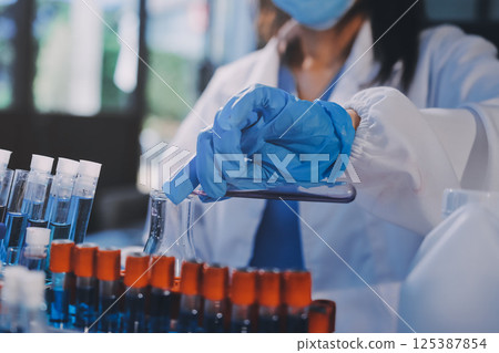 Researcher using a professional microscope Researcher using a professional microscope 125387854