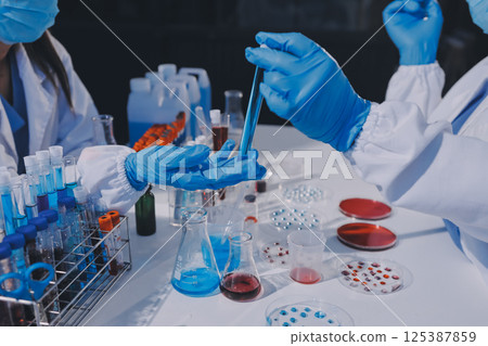 Researcher using a professional microscope 125387859