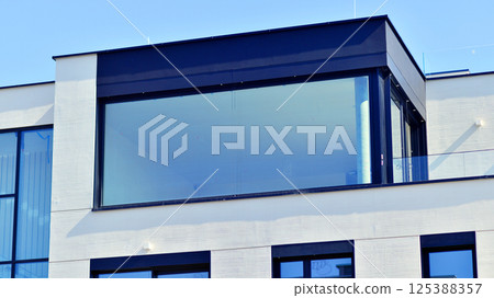 Modern architecture of urban residential apartment buildings on a sunny day. Low-rise apartment buildings with large windows and extensive terraces. White facade of a modern apartment building. Modern architecture of urban residential apartment buildings on a sunny day. Low-rise apartment buildings with large windows and extensive terraces. White facade of a modern apartment building. 125388357