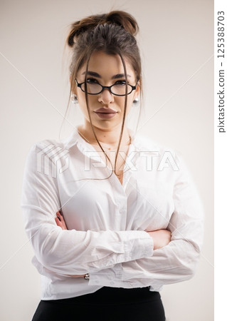 Confident Young Woman in Formal Attire with Crossed Arms, Serious Expression 125388703