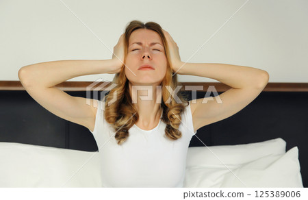 Exhausted tired woman suffering from headache, stress, fatigue, temples pain, migraine, loud noise 125389006