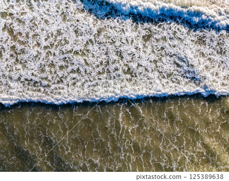 Top view beach waves nature background,Amazing waves crashing on sandy shore seascape view 125389638