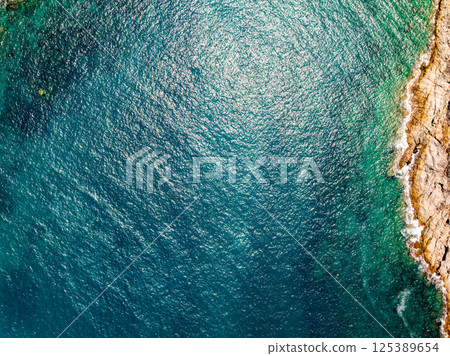 Top view seashore waves nature background,Amazing waves crashing on rocks seascape view Top view seashore waves nature background,Amazing waves crashing on rocks seascape view 125389654