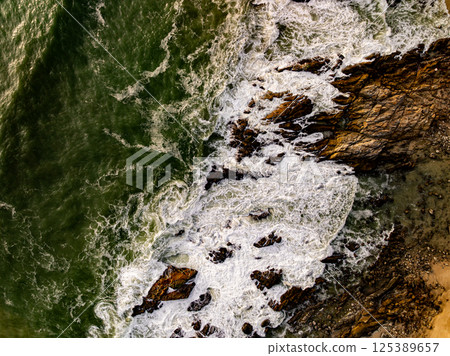Top view seashore waves nature background,Amazing waves crashing on rocks seascape view Top view seashore waves nature background,Amazing waves crashing on rocks seascape view 125389657