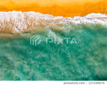 Top view beach waves nature background,Amazing waves crashing on sandy shore seascape view Top view beach waves nature background,Amazing waves crashing on sandy shore seascape view 125389670
