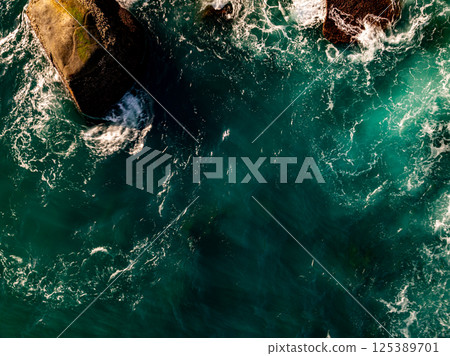 Top view seashore waves nature background,Amazing waves crashing on rocks seascape view 125389701
