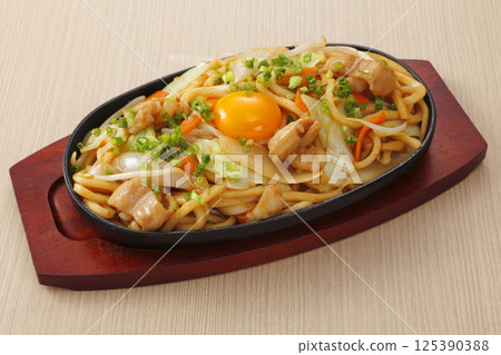 Fried udon noodles topped with egg yolk Fried udon noodles topped with egg yolk 125390388