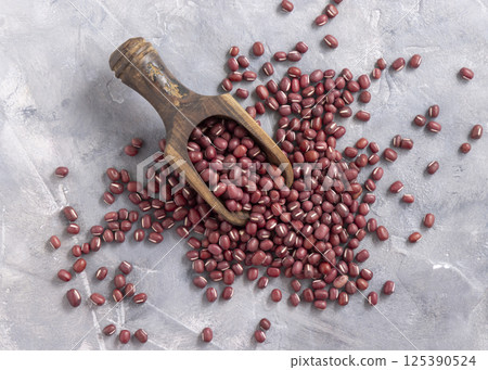 Scoop full of dried azuki beans on gray top view. East Asian legumes, vegetarian protein source 125390524