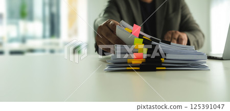 on his laptop, managing corporate reports and legal paperwork at his office desk. on his laptop, managing corporate reports and legal paperwork at his office desk. 125391047