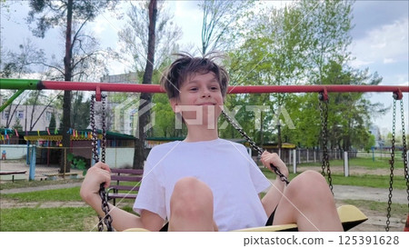 Happy freedom boy swinging on a swing. Close up. Happy teenager swinging on a swing. Happy freedom boy swinging on a swing. Close up. Happy teenager swinging on a swing. 125391628