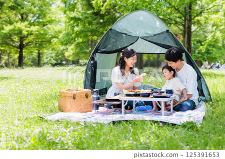 Friendly family enjoying cooking at camp, outdoor image 125391653
