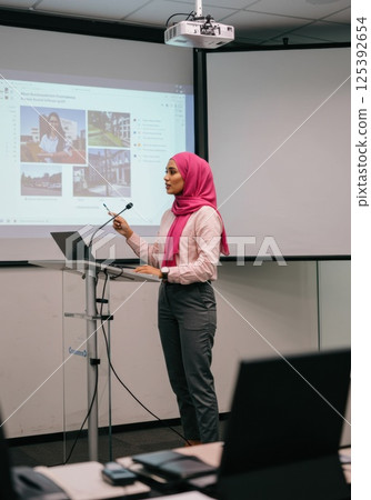 A woman in a hijab giving a presentation (AI generated image) 125392654
