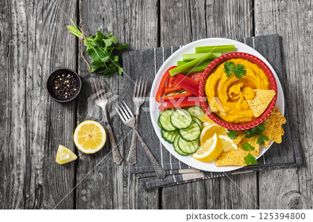 creamy roast carrot hummus in red bowl creamy roast carrot hummus in red bowl 125394800