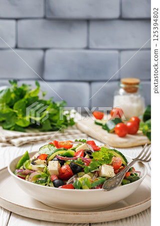 greek salad of veggies, olives, cheese in bowl 125394802